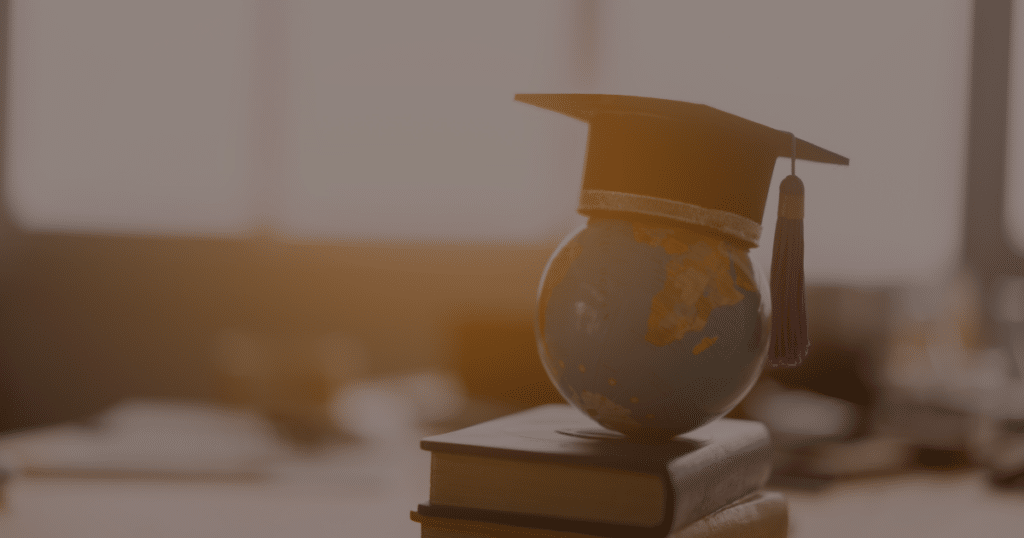 a globe with a graduation cap on top of a book
